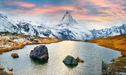 matterhorn, across from lake stellisee  above the city of zarmatt, is a famous landmark surrounded by larch trees and cliffs, one of the symbols of switzerland.