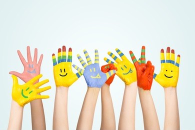 painted children's hands in different colors with smilies