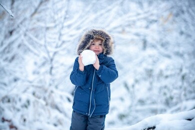 winter at countryside. little child boy walking in winter field. well dressed enjoying the winter. kids winter portrait