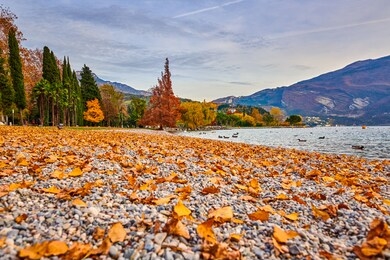 beautiful and colorful autumn in riva del garda, garda lake surrounded by mountains, trentino alto adige region, lago di garda, italy