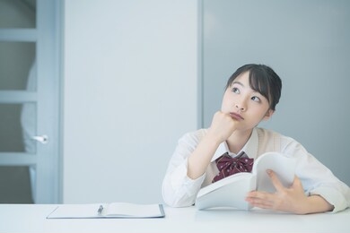 young asian student reading a book in room.
