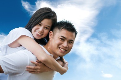 a shot of an asian couple outdoor doing a piggback ride