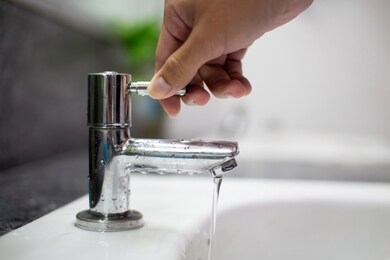 men's hands turn off the tap to reduce global warming from turning on the waste water.