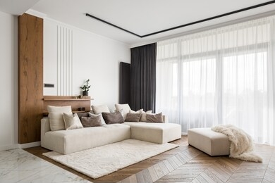 elegant and comfortable designed living room with big corner sofa, wooden floor and big windows