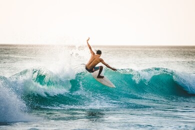 professional surfer riding waves in dreamland beach, bali, indonesia. men catching waves in ocean. tail slide water surf, action water board sport