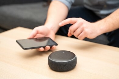 man using virtual assistant and smart speaker at home