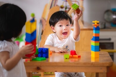 baby age 1 years and 2 years old. asian boy and girl playing with colorful plastic blocks.children are learning to design and build from toys. hand muscle development. 