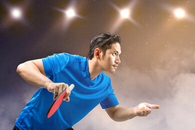 asian table tennis player man serving the ball with spotlights background