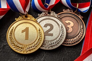 gold, silver and bronze medal with ribbons. award for first, second and third place in the competition. prize to the champion. black background.