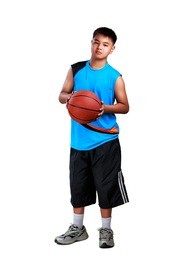 young asian boy standing with basketball, isolated over white