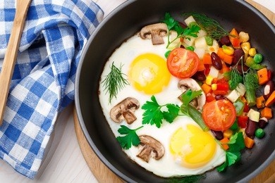 fried eggs in a pan with vegetables