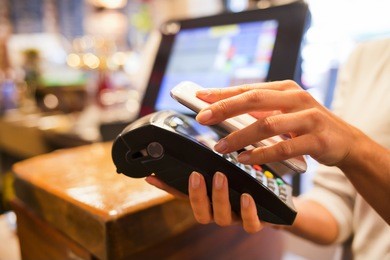 woman paying with nfc technology on mobile phone, restaurant, cafe, bar
