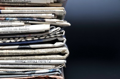 stack of newspapers on black background