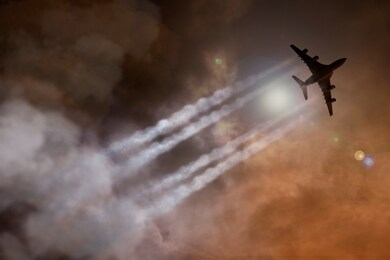 passenger plane surrounded by exhaust gases and clouds