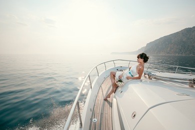 woman lies on a luxury yacht in the sea and looking to the horizon