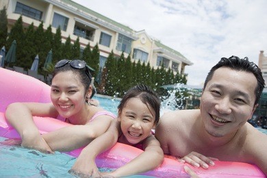 smiling family portrait in the pool