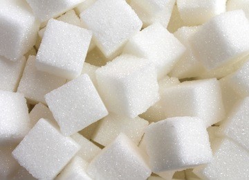 sugar background sweet food ingredient with a close up of a pile of delicious white lumps of cubes as a symbol of cooking and baking and the diet health risks related to diabetes and calorie intake.