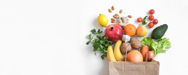 healthy food background. healthy vegan vegetarian food in paper bag vegetables and fruits on white, copy space, banner. shopping food supermarket and clean vegan eating concept.