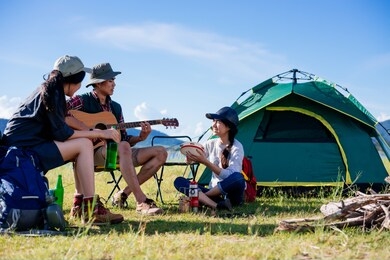 camping camp in nature happy friends party and playing guitar together in summer at nature forest