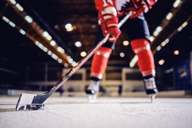 close up of hockey player skating with stick and puck.