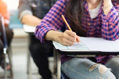 high school,university student study.hands holding pencil writing paper answer sheet.sitting lecture chair taking final exam attending in examination classroom.concept scholarship for education abroad