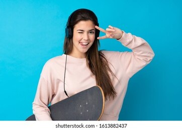 teenager girl over isolated blue background with a skate with happy expression
