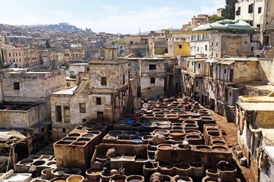 tanners working leather in the old tannery of fes, morocco