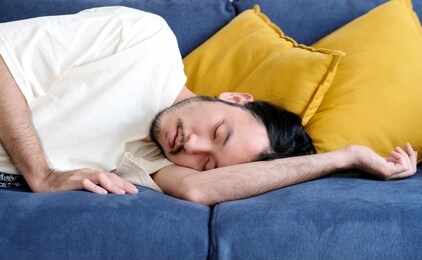 young handsome asian man sleeping on sofa at home living room, people lifestyle