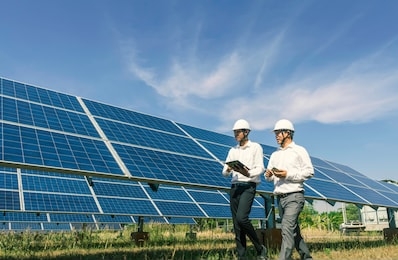 the solar farm(solar panel) with two engineers walk to check the operation of the system, alternative energy to conserve the world's energy, photovoltaic module idea for clean energy production.