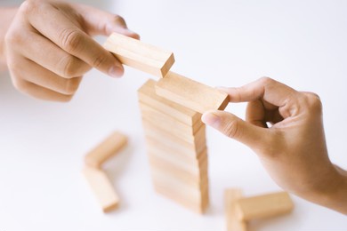 group of people building up the tower, business risk and strategy concept.