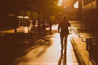 man walking in the street on a sunny afternoon