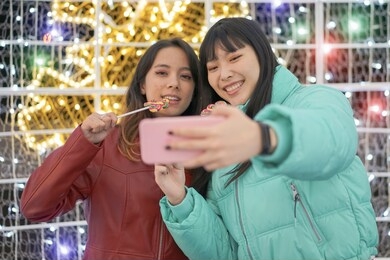 selfie of young smiling teenagers having fun together. happy young friends with sweet candies in their hands. travel and friendship concept – image