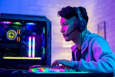 young asian handsome pro gamer playing in online cyber sport game at home