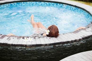 beautiful woman relaxing in jacuzzi at spa center
