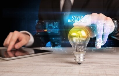 businessman holding lightbulb with cyber insurance inscription, online security idea concept