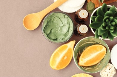 homemade skin care with green cosmetic bentonite clay for facial mask with lemon essential oil, top view ingredients on table making diy beauty products. 