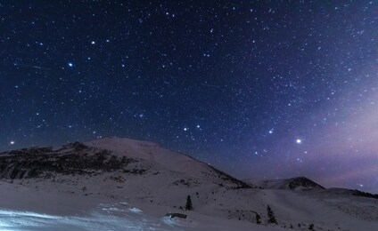 images of night winter mountains with houses and trees, and night sky and a milky way with millions of stars.