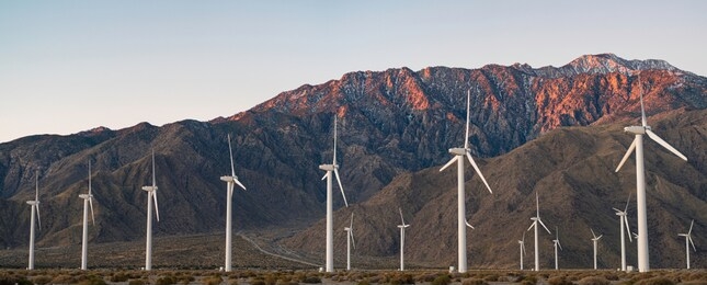 palm springs, california wind turbines. early morning glow on san jacinto mountains. renewable energy though a windy corridor in the desert.
