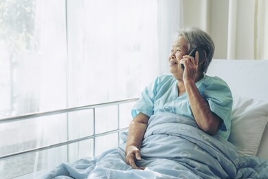elderly patients in hospital bed patients using smart phone call to descendant relatives feel happiness - medical and healthcare concept