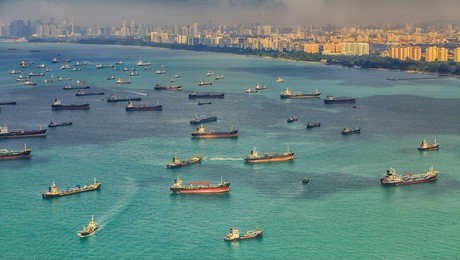 landscape from bird view of cargo ships entering one of the busiest ports in the world, singapore.