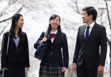 family walking under a row of cherry trees