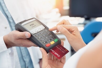 payment by credit card with terminal. woman enters the pin code