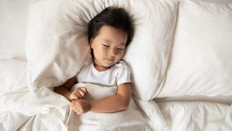 calm cute vietnamese little girl lie relax on soft pillow in white comfortable bed, top view of small asian child sleep rest in cozy home bedroom, take nap daydream or see dreams, relaxation concept