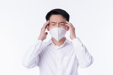 close up young asian male businessman wearing pollution mask with gesture action express ill sickness bad health from weather with pm2.5 environment city air problem