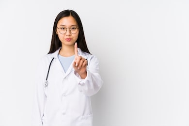 young doctor chinese woman isolated showing number one with finger.