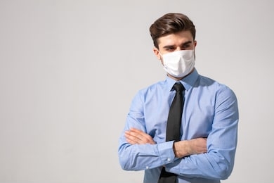 is time to protect all the time. elegant man wearing a mouth protection to prevent getting sick at work or on the way to work