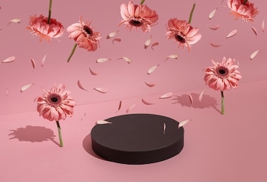 podium for the product around the flowers on a pastel pink background.