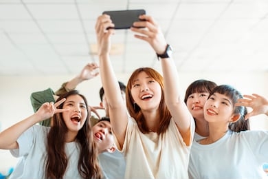 happy young group of teenagers making fun selfie in classroom