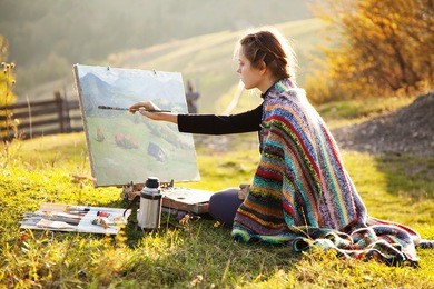young artist painting an autumn landscape