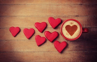 cup of coffee with heart symbol and candy around.